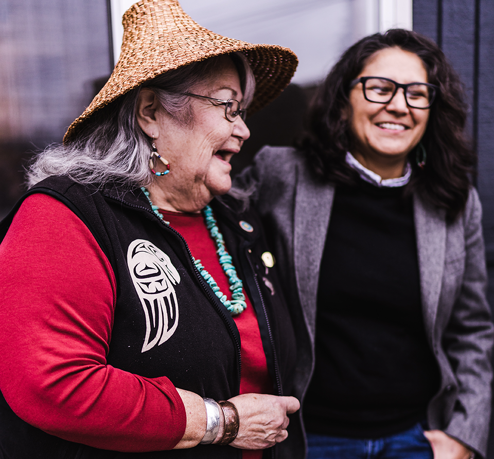 Photo of two Alaskan Native women laughing in conversation