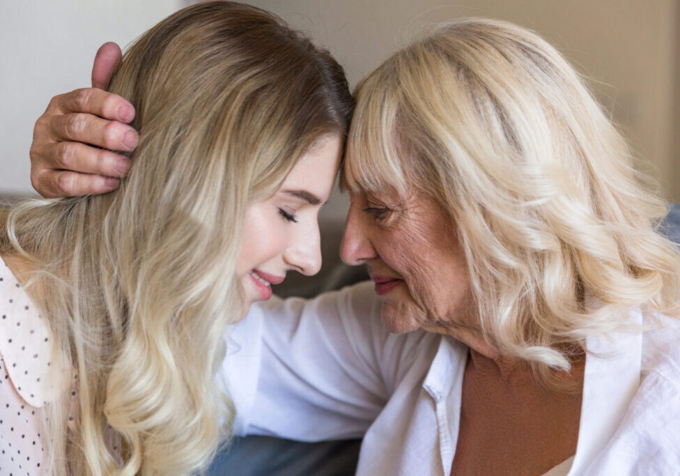 storyblocks-close-up-of-senior-grandmother-embracing-her-granddaughter-with-eyes-closed-indoors_BRMV073pcZ-scaled